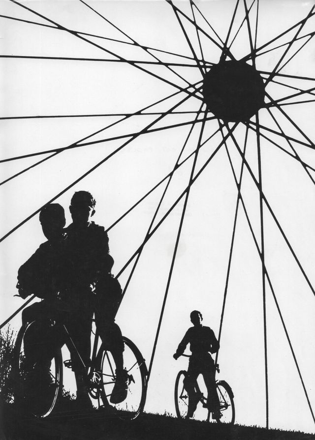 Cyclists silhouetted against wheel spokes